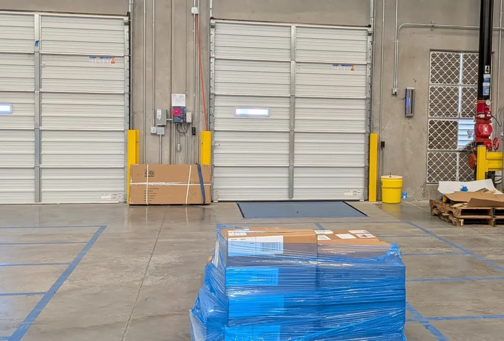 Warehouse dock doors with a shrink-wrapped pallet staged in front of them